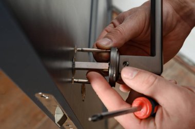 A man installs a door handle in a door, carpentry work at home, repair and restoration work.