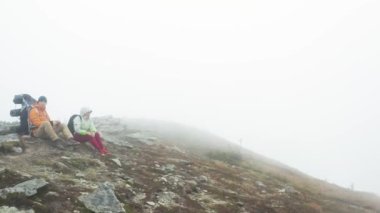 Turistlerin geri kalanı zirveye tırmandıktan sonra dağlardan kalkan insansız hava aracı videoları, Spitz Dağı 'nın tepesinde, sis altındaki turistler....