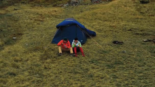 其余的游客爬到山顶后 有无人驾驶飞机从山上的游客那里起飞的视频 还有在帐篷附近吃饭的游客 — 图库视频影像