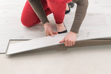 Zemin kurulumu, yeni bir kuvars stili vinil zemin döşeme onarımı, döşeme onarımı, bir kadın döşeme montajı.