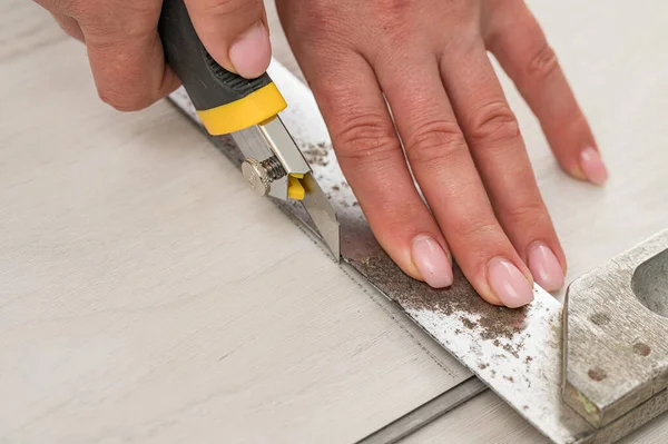 女校长用文具刀切割石英玻璃地板 安装地板 由妇女负责修理工作 — 图库照片