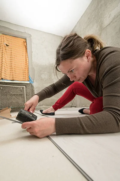 女性は自宅で石英ビニール床をインストールします 仕事から疲れ女性 石英ビニール床のインストール — ストック写真