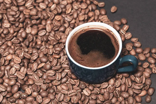 어두운 배경에 커피콩을 곁들인 커피에서 나오는 가벼운 — 스톡 사진