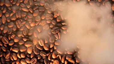Dumanlı kahve çekirdekleri, kahve çekirdekleri dokusunun üst görüntüsü, yüksek çözünürlüklü video ve yavaş çekimde duman..
