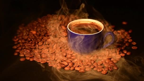 軽い煙の中でローストコーヒー豆の間のコーヒーカップ Hdビデオとスローモーション — ストック動画
