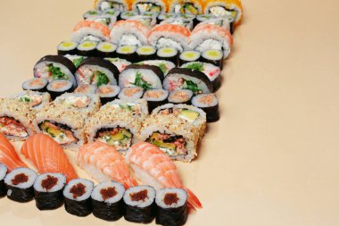 Maki ve nigiri, balıklı suşi, taze somon, karides ve peynir, avokado ruloları. Futomaki ve Philadelphia ile California. Suşi hazırla.