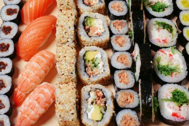 Maki ve nigiri, balıklı suşi, taze somon, karides ve peynir, avokado ruloları. Futomaki ve Philadelphia ile California. Suşi hazırla.