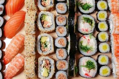 Maki ve nigiri, balıklı suşi, taze somon, karides ve peynir, avokado ruloları. Futomaki ve Philadelphia ile California. Suşi hazırla.