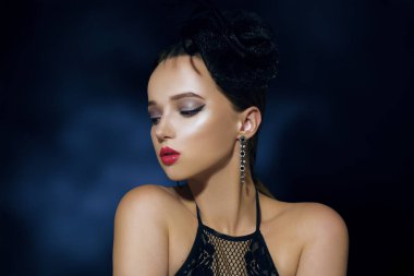 90 'ların tarzında bir kız, Chicago tarzı. Şapka, kafasında dekoratif tüy olan saç bandı. İnanılmaz mücevherler, uzun elmas küpeler..