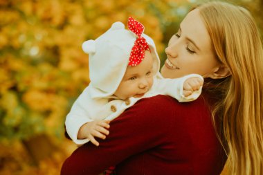 Mutlu, genç bir aile annesi ve küçük bir kız çocuğu dışarıda eğleniyorlar. Ebeveynler uçan bebeklerini öperler. Anne ve kızı sonbaharda bir parkta yaprakları dökülüyor, güzel bir sonbahar gününün tadını çıkarıyorlar.. 
