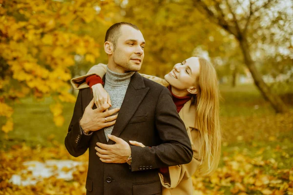 Kız ve erkek ya da sevgili kucaklaşması. Parkta aşık bir çift. Sonbahar. Erkek ve kadın, sonbaharda düşen yapraklarla gülerek güzel bir sonbahar gününün tadını çıkarırlar. Sonbaharda genç bir çift.