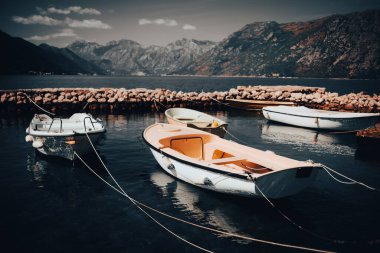 Doğanın karanlık atmosferik resmi. Karadağ dağları, sudaki tekneler. Yağmurdan önce hava durumu, şık kartpostal.