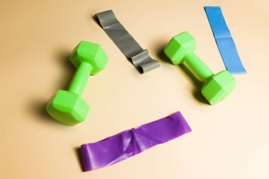 Çıplak arka planda spor ve elastik bantlar için ağırlıklar, spor sağlığı