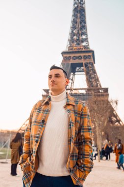Eyfel Kulesi 'nin arka planındaki adam poz veriyor. Erkek turistler güler ve gülümser. # Yolculukta yakışıklı esmer #.