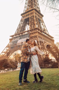 Paris 'teki Eyfel Kulesi' nin önünde öpüşen bir çift. Romantik bir gezi, Avrupa 'da balayı. Fransa 'nın aşk şehri.
