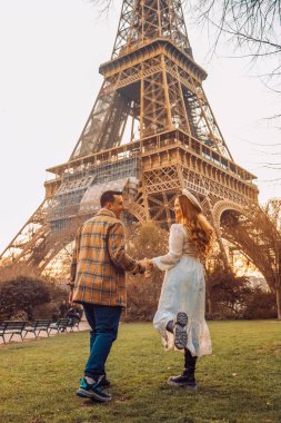Paris 'te arka planda Eyfel Kulesi olan bir çift. Romantik bir gezi, Avrupa 'da balayı. Fransa 'nın aşk şehri. Beni takip edin. Aşk.