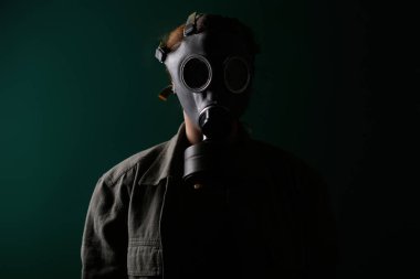 Gaz maskeli bir askerin fotoğrafı, kıyamet, nükleer silahlar, bir istasyonun atom patlaması, kimyasal ve nükleer silah koruması. Yeşil arka planda maskeli bir kız, savaş