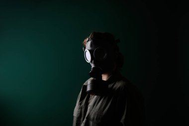 Gaz maskeli bir askerin fotoğrafı, kıyamet, nükleer silahlar, bir istasyonun atom patlaması, kimyasal ve nükleer silah koruması. Yeşil arka planda maskeli bir kız, savaş