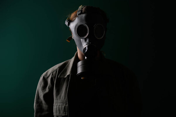 Фото военнослужащего в противогазе, апокалипсисе, ядерном оружии, атомном взрыве станции, защите химического и ядерного оружия. Девушка в маске на зеленом фоне, война