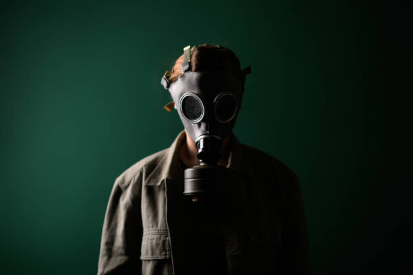 Фото военнослужащего в противогазе, апокалипсисе, ядерном оружии, атомном взрыве станции, защите химического и ядерного оружия. Девушка в маске на зеленом фоне, война