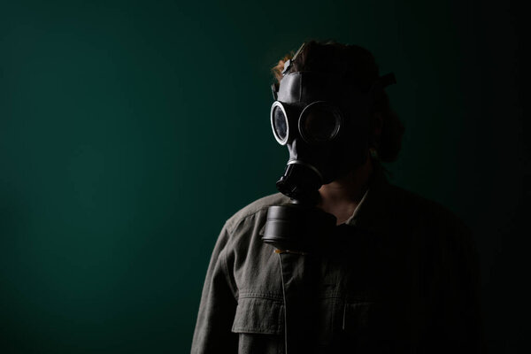 Фото военнослужащего в противогазе, апокалипсисе, ядерном оружии, атомном взрыве станции, защите химического и ядерного оружия. Девушка в маске на зеленом фоне, война