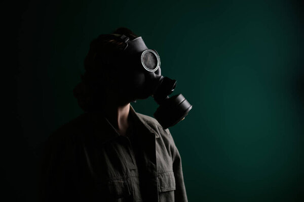 Фото военнослужащего в противогазе, апокалипсисе, ядерном оружии, атомном взрыве станции, защите химического и ядерного оружия. Девушка в маске на зеленом фоне, война