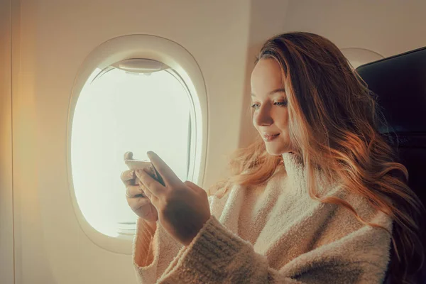 Een Mooi Meisje Zit Een Vliegtuig Naar Telefoon Kijken Een — Stockfoto