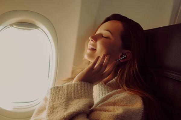 Ein Schönes Mädchen Sitzt Flugzeug Fenster Und Hört Musik Oder — Stockfoto