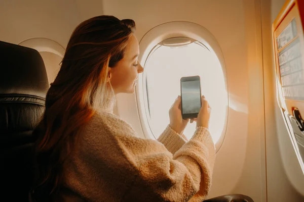 Het Meisje Zit Het Vliegtuig Neemt Een Foto Aan Telefoon — Stockfoto