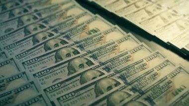 Bir sürü para, 100 banknotluk banknotlar halinde dolar. Masada milyonlar yatıyor, zengin..