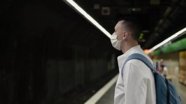 Metroda maskeli bir adam duruyor. Kofid 'e karşı eylemler, halka açık yerlerde maske takmalar. Metroda tren bekleyen bir adam..