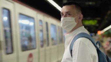 Metroda maskeli bir adam duruyor. Kofid 'e karşı eylemler, halka açık yerlerde maske takmalar. Metroda tren bekleyen bir adam.