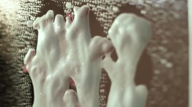 Glass cleaner splashes on a mirror on which there is an inscription with lipstick. Cleaning