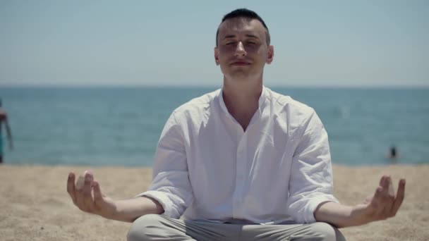 Man Sitter Stranden Mot Bakgrund Havet Eller Havet Och Mediterar — Stockvideo