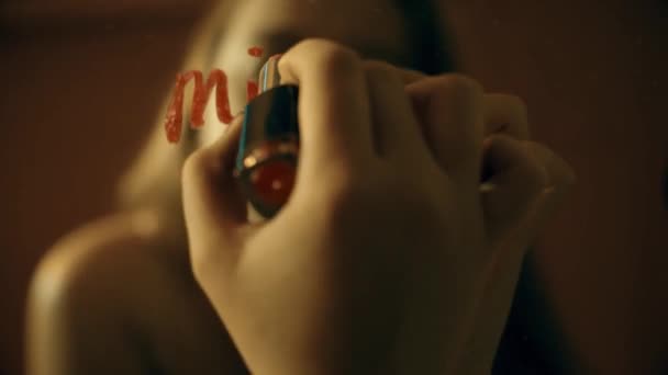 女の子は赤い口紅で鏡にメモを書きます あなたを欠場 — ストック動画
