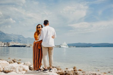 Bir çift deniz ve dağların arkaplanına karşı sahil boyunca yürür. Aşıklar seyahati. Aşk ve balayı. Erkek ve kız doğaya hayran.