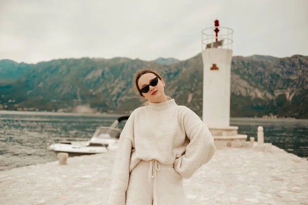 暖かい白いスーツの女の子が灯台の近くの島を歩いている モンテネグロ — ストック写真