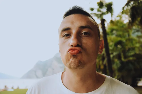 A man shows an air kiss to the camera. Gentle and kind man, romantic. Man kissing the camera