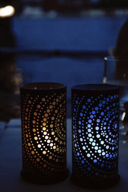 The candles on the table are blue and yellow. Rest by the sea