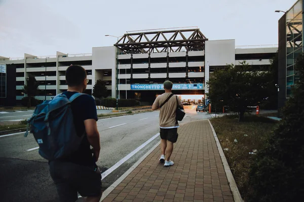 Italy. Venice. 09.07.2022 A group of people walk towards the parking lot against the backdrop of a sunset in Venice. Traveling with friends tourists