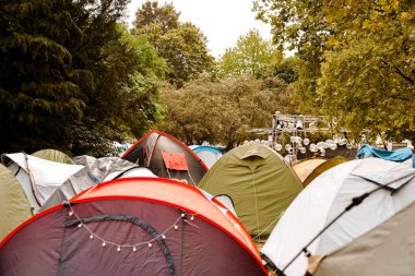 Tent camp in the forest, a lot of tents. Rest in the forest at the festival.