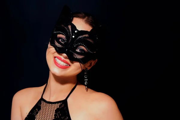 The girl in the mask. Masquerade, halloween. Girl in a cat mask. Catwoman on a beautiful background in a beautiful lace top with long earrings