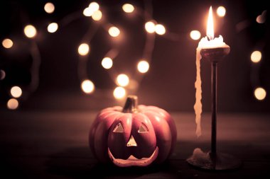 Cadılar Bayramı balkabağı duvar kâğıdı, arka planda mum ve sicim ışıkları var. Renkli vintage renkler.