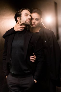 Stüdyoda siyah ceketli ve kravatlı genç bir çift