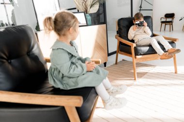 Evde kamerayla oynayan sevimli çocuk.