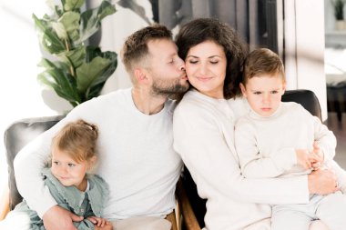 Genç ve mutlu bir aile. Erkek kadını öpüyor  