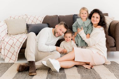 Evde çocuklar poz verirken mutlu bir aile. 