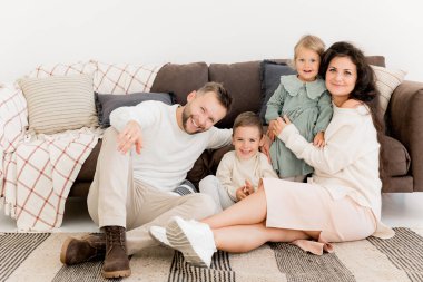 Evde çocuklar poz verirken mutlu bir aile. 