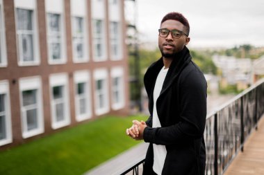 Dışarıda poz veren yakışıklı, Afro-Amerikan bir adamın portresi.