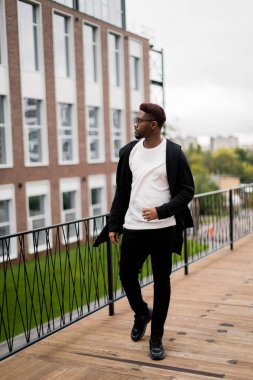 Dışarıda poz veren yakışıklı, Afro-Amerikan bir adamın portresi.